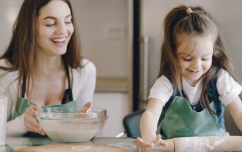 A joyful moment as a mother and daughter bond while baking pastries at home.